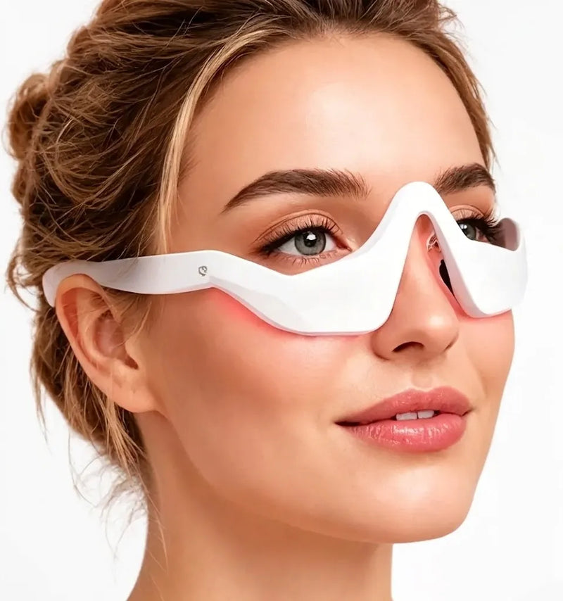 A close-up of a woman wearing a white LED facial treatment mask that glows with a red light along her cheek, set against a clean white background.