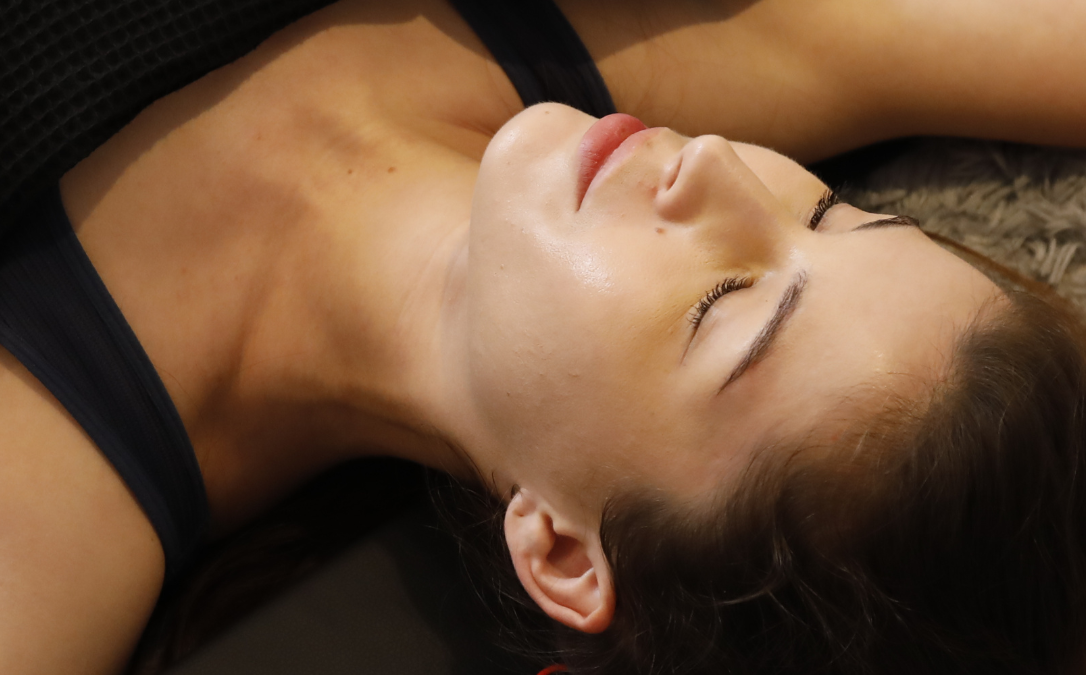 A woman relaxes during an infrared sauna blanket treatment