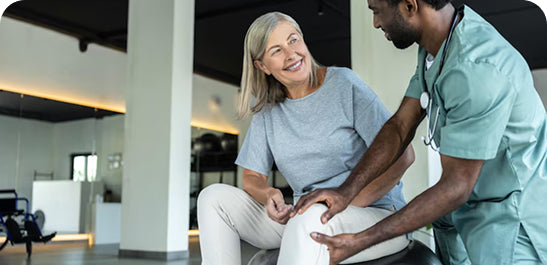 Nurse examining a patient's knee in a medical office setting